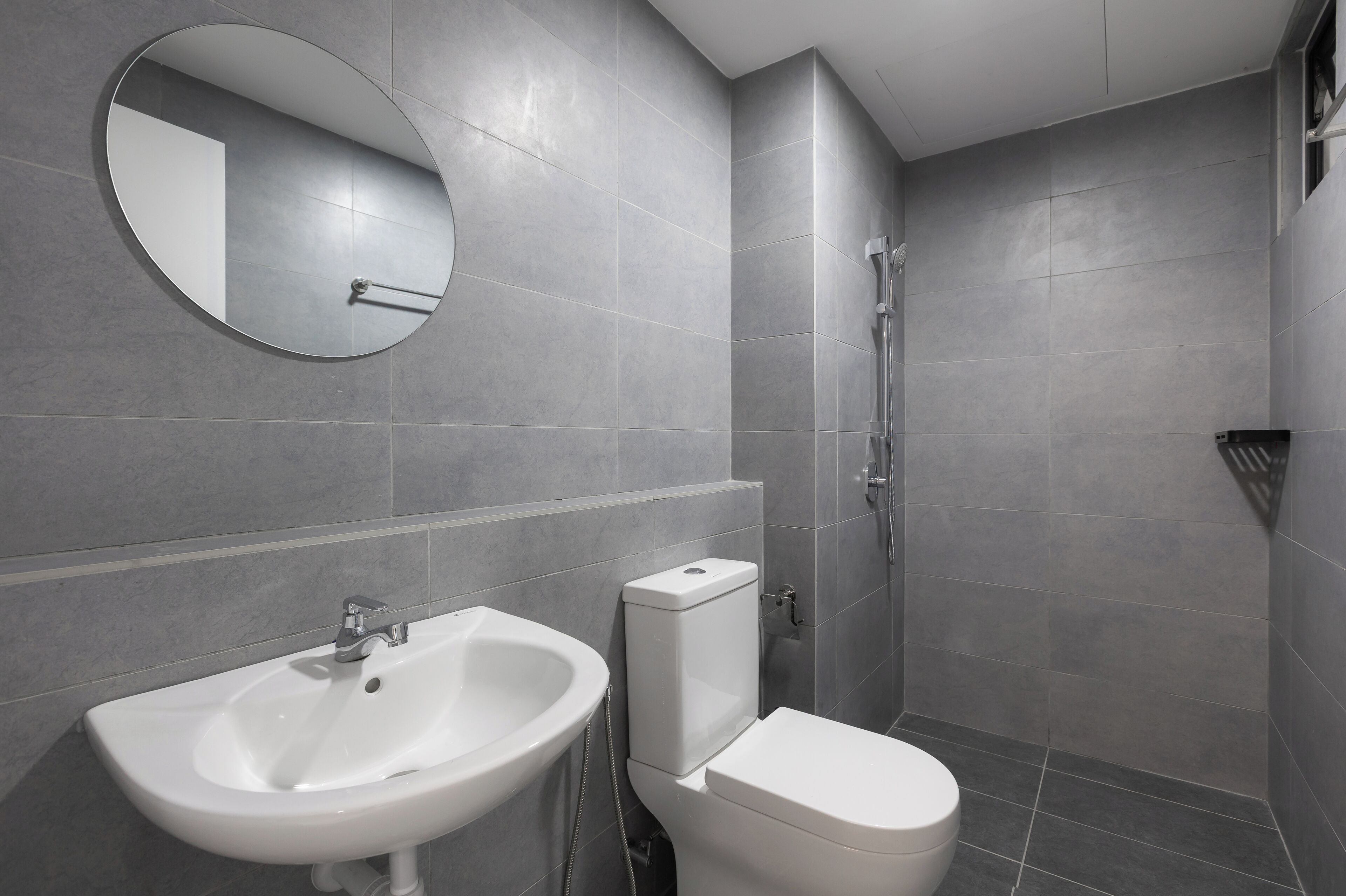 A modern bathroom with a sink, toilet, and shower.