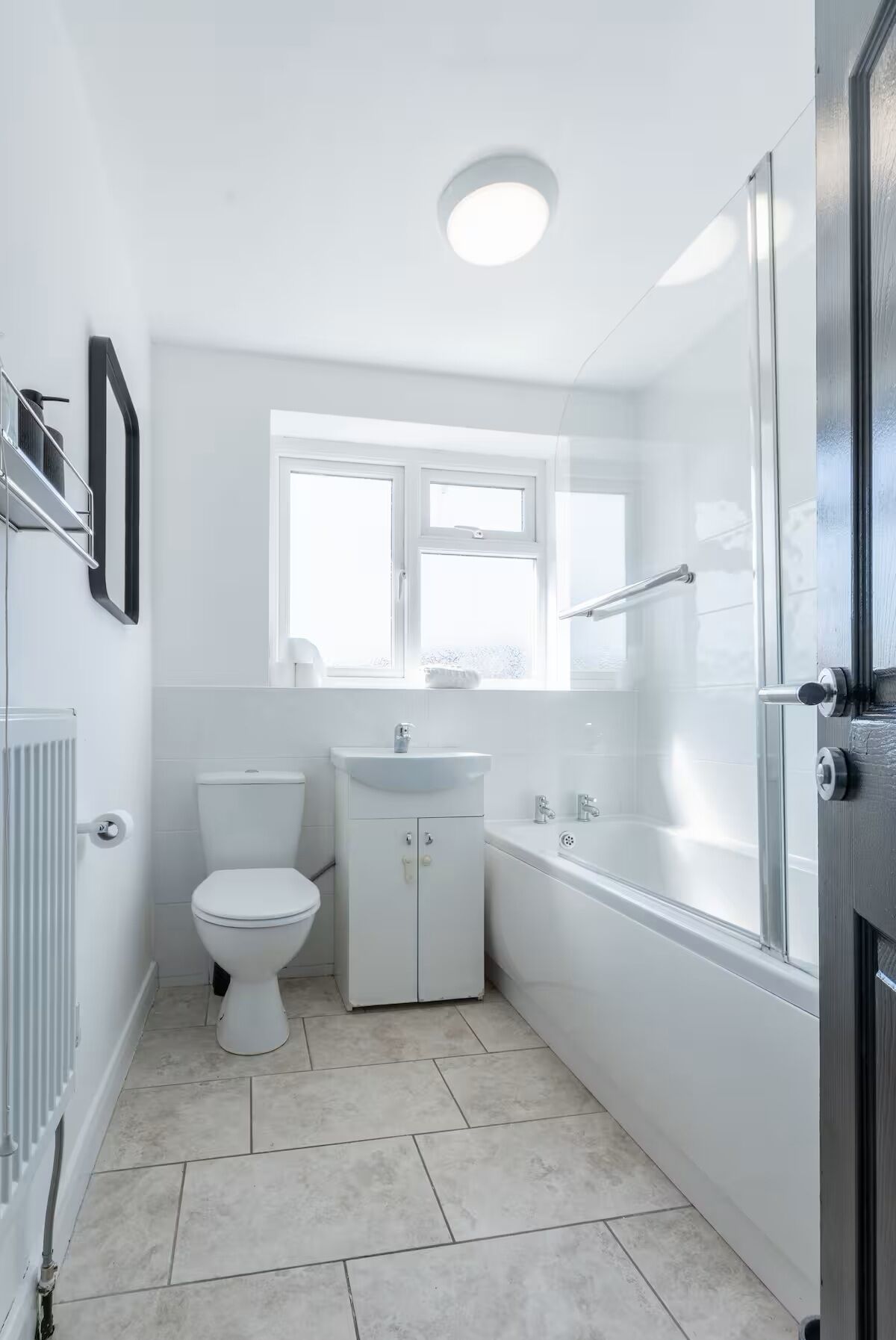 Une salle de bain moderne et compacte, équipée de toilettes, d’un lavabo et d’une baignoire.