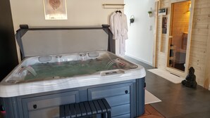Et spa-rum med et boblebad, en trævæg og en statue.
