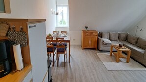 Un espacio habitable compacto con comedor, kitchenette y sofá.
