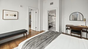 Una camera da letto con un letto, una scrivania, una sedia, una panca e una ventola a soffitto.
