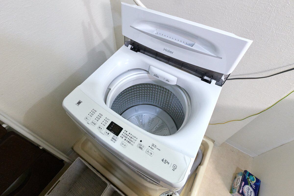 A front-loading Haier washing machine with a digital display and control panel.