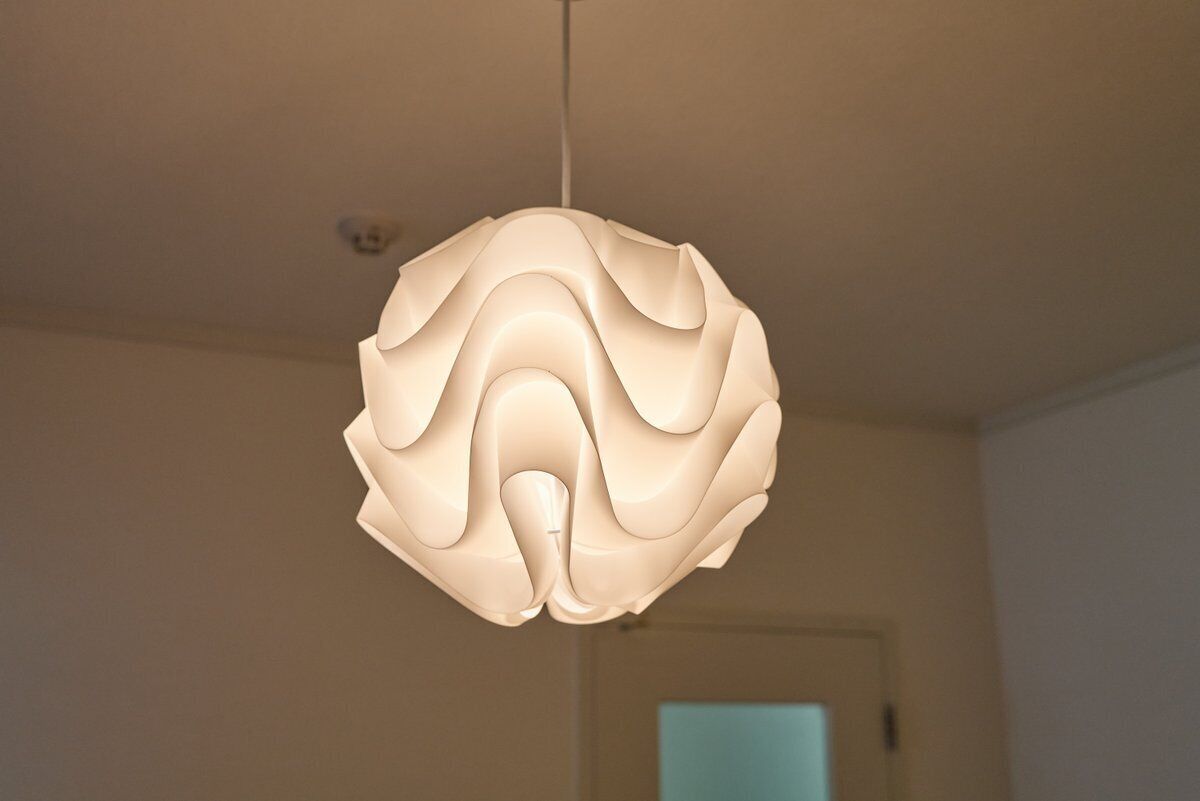 A spherical pendant light fixture with a smooth, flowing design.