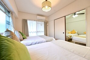 Ett hotellrum med två sängar, en stor spegel och en takfläkt.
