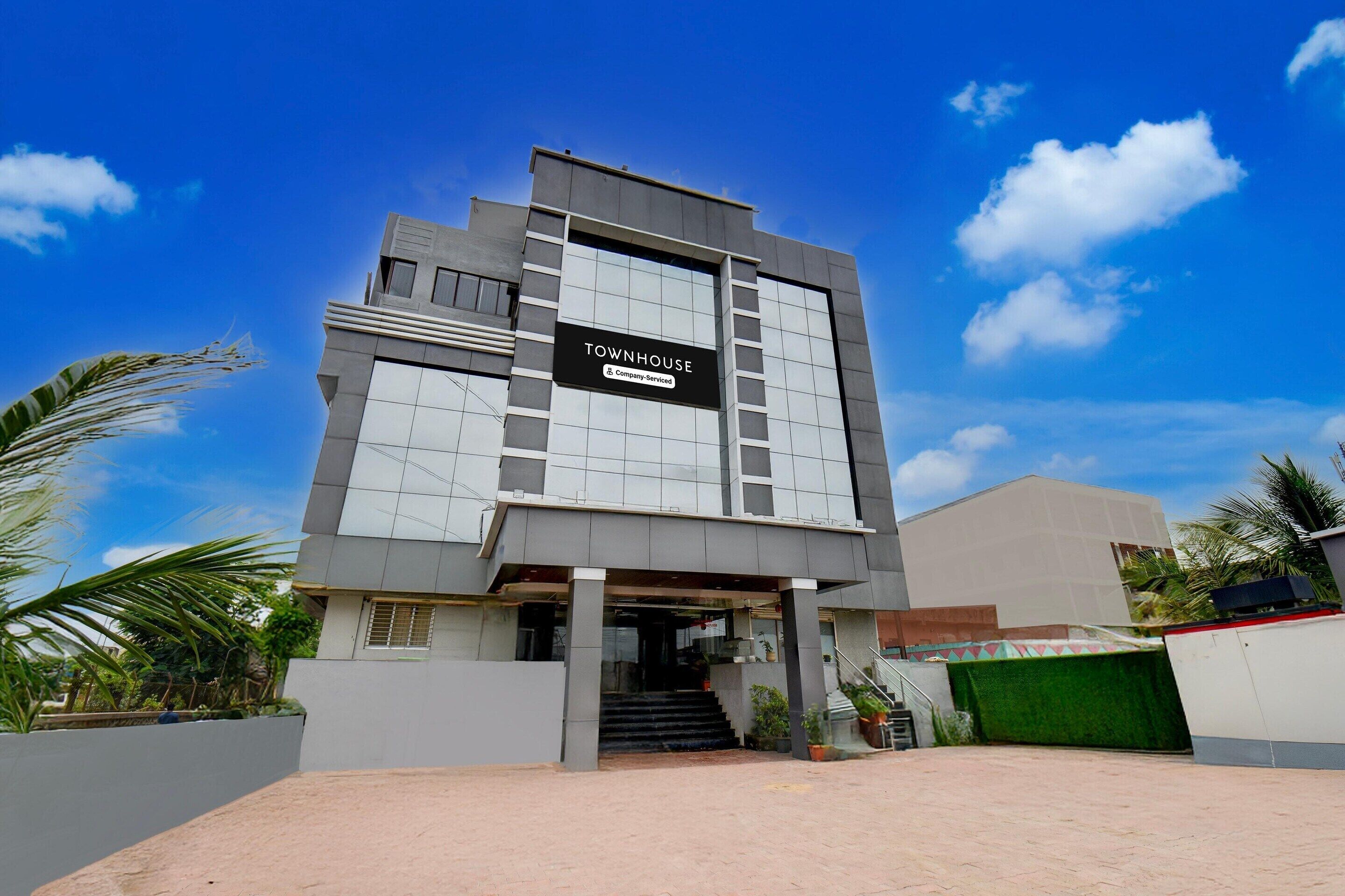 A modern building with a sign that reads 'TOWNHOUSE Company-Serviced'.