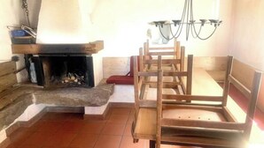 A room with a fireplace, wooden chairs, a bench, and a chandelier. - Rustic Monti - Rasa - Centovalli (Centovalli)