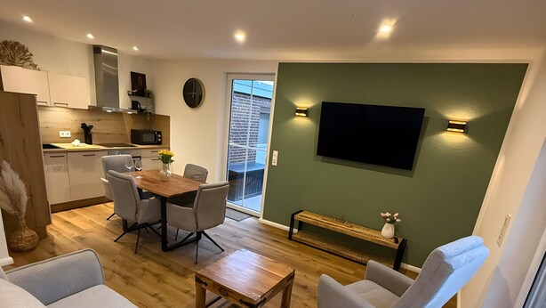 Una sala moderna con un sofá, una mesa de centro y un comedor con sillas.
