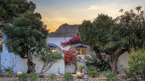 A courtyard with a stone wall, potted plants, and a view of a mountain. - Hibiscus by Sun & Sea Homes (Calpe)