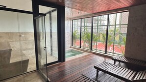 A modern interior with wooden flooring, a glass door leading outside, and a view of a swimming pool and greenery. - 2 Suites Setor Bueno & Vaca Brava Hop Amparo (Goiânia)