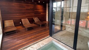 A modern indoor pool area with wooden flooring and lounge chairs. - 2 Suites Setor Bueno & Vaca Brava Hop Amparo (Goiânia)