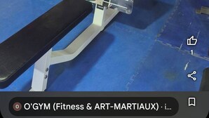 A gym with exercise equipment, a bench, and a mirror. - Atlas City Center Apartment (Fes)