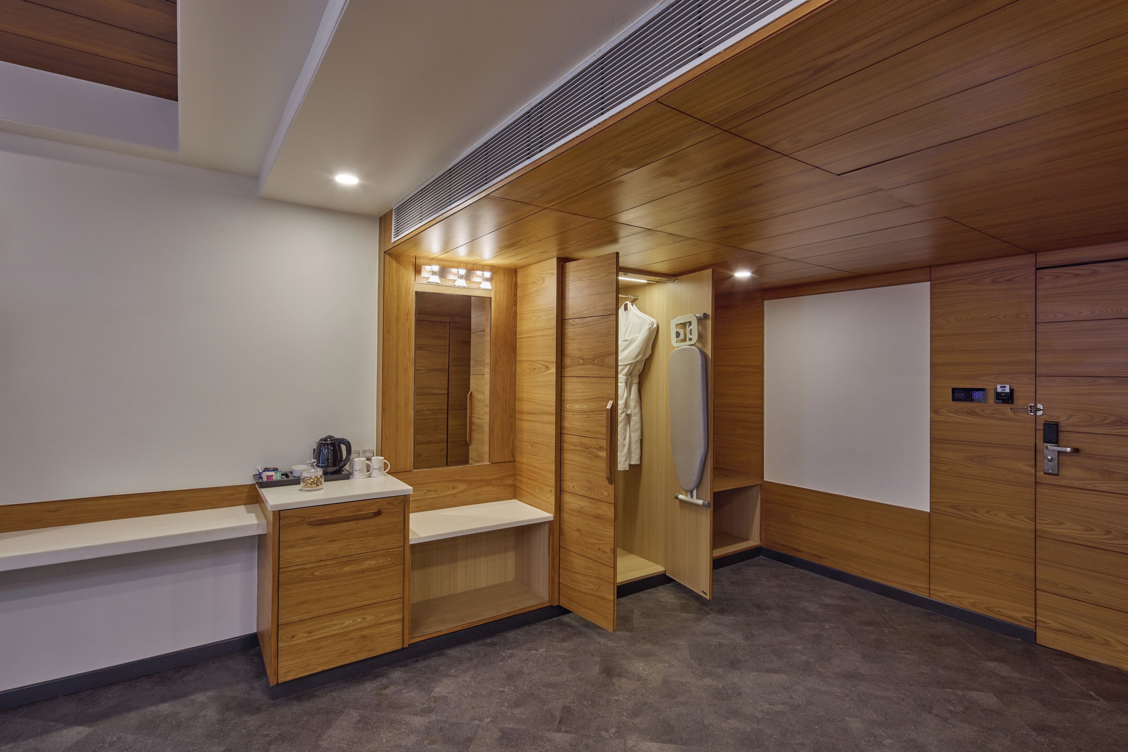 Une salle de bain moderne avec un lambris en bois, un lavabo équipé d’une machine à café et un espace douche.