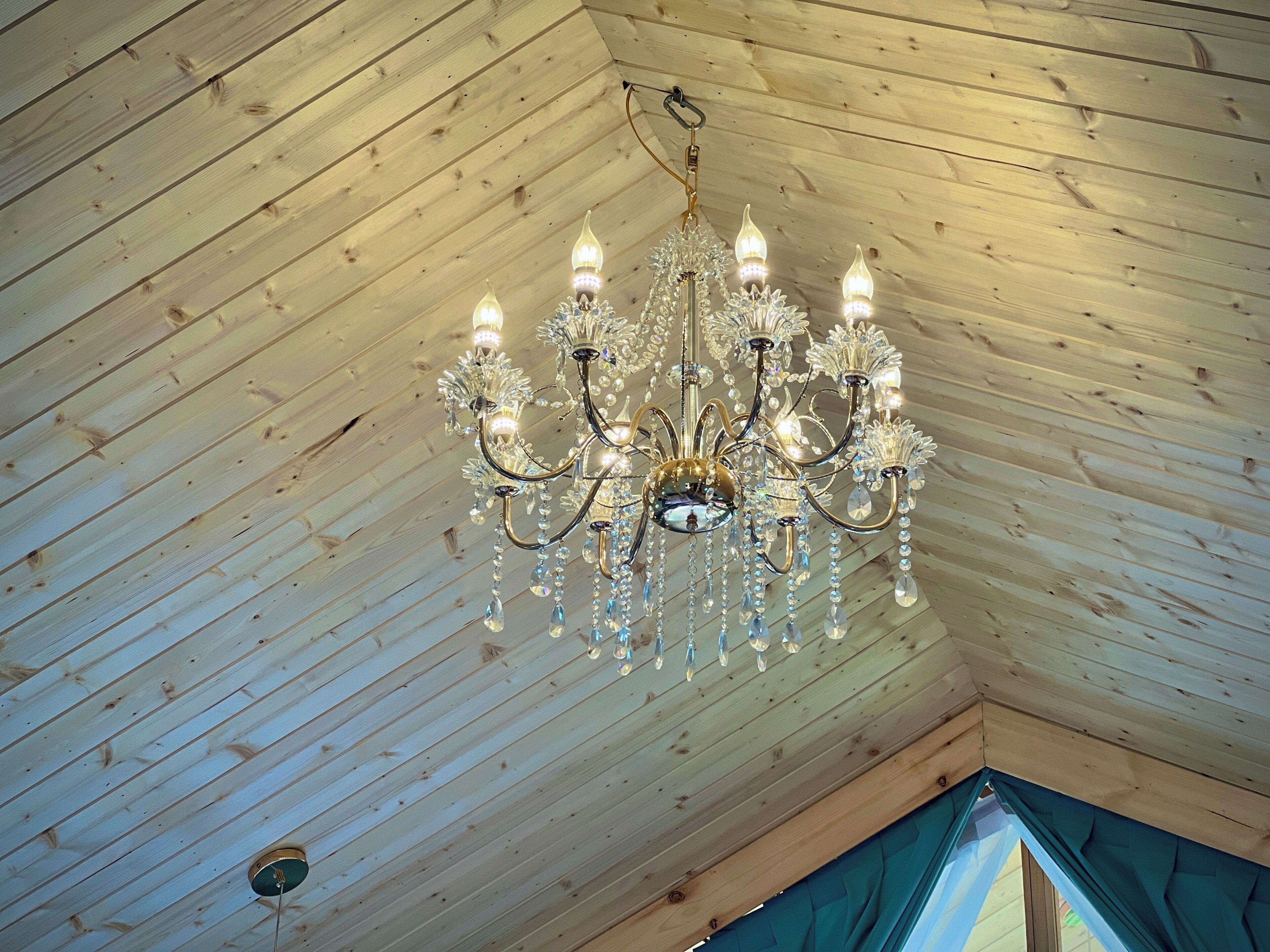 Un candelabro en una habitación con techo de listones de madera.