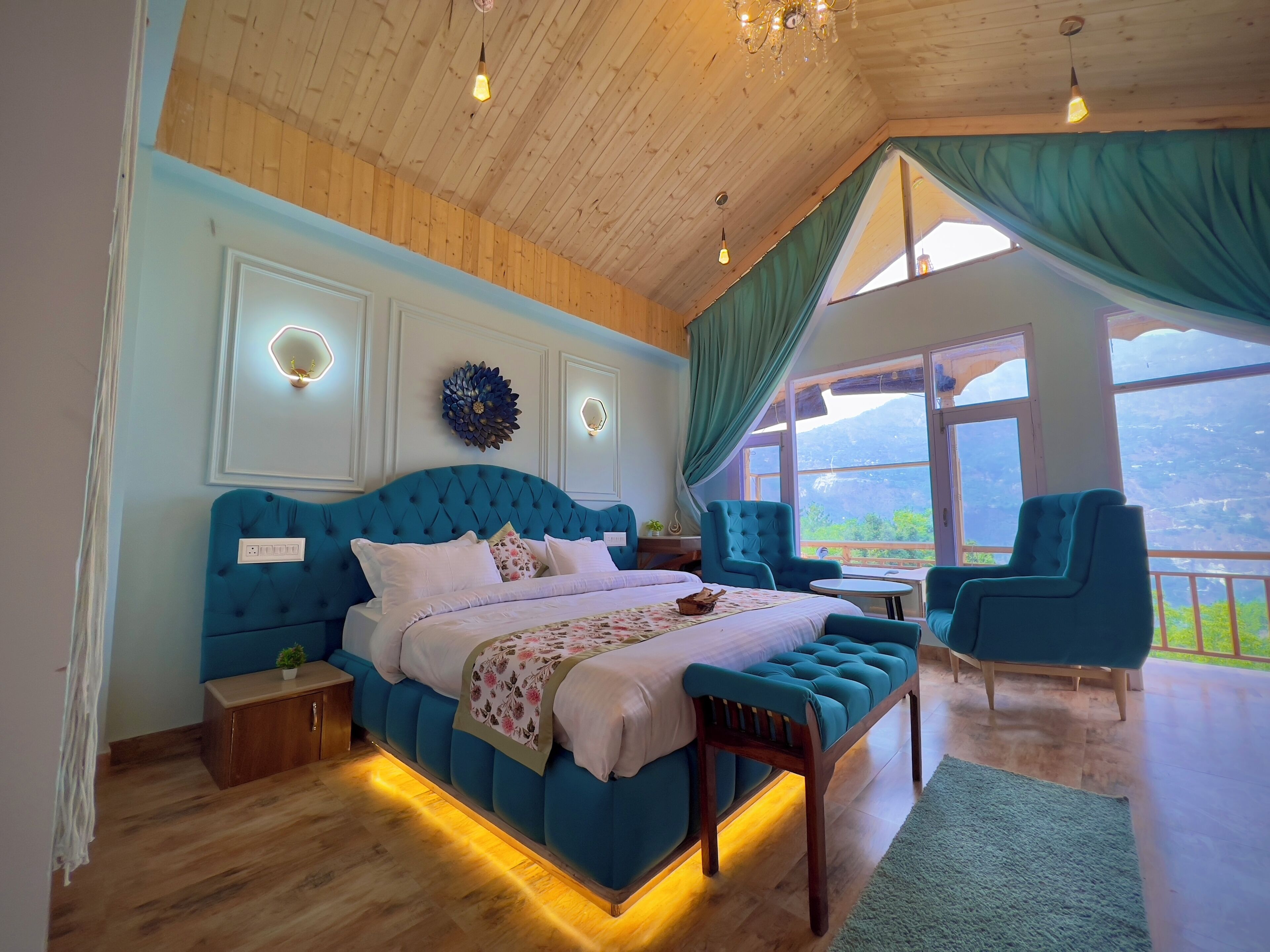 A bedroom with a large bed, a wooden ceiling, and a view of the outdoors.
