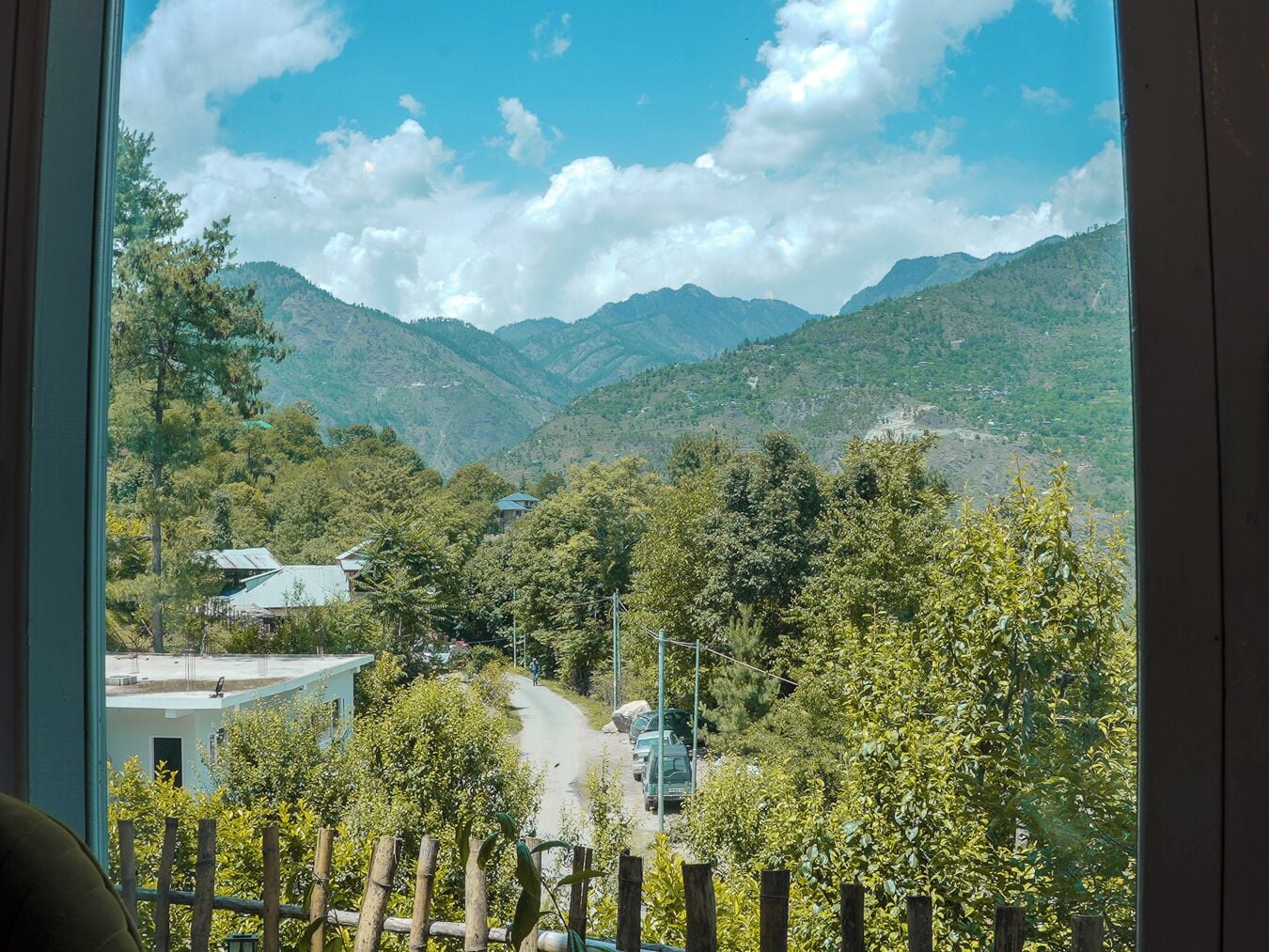 Vista di un paesaggio montuoso con una strada che attraversa un villaggio.
