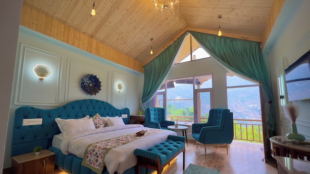 Een slaapkamer met een groot bed, een houten plafond en uitzicht op de omgeving.