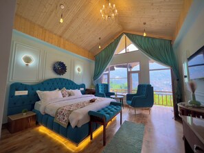 Una camera da letto con un letto grande, un soffitto in legno e vista sull'esterno.