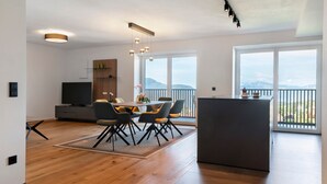 A modern kitchen with a dining area, large windows, and a view of the mountains.