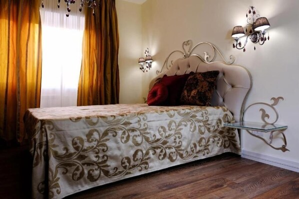 Una camera da letto con un letto, tende, applique e un lampadario.
