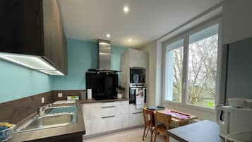 Una cocina moderna con horno integrado, microondas y un amplio ventanal que ofrece vistas al exterior.
