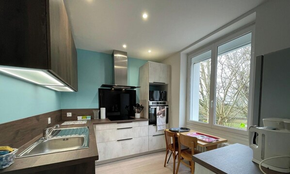 A modern kitchen with a built-in oven, microwave, and a large window providing a view of the outdoors.