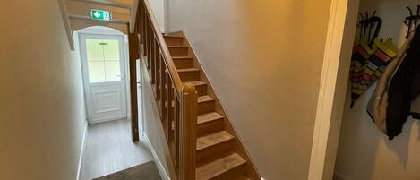 A staircase leading to a door with an emergency exit sign above it.