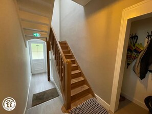 A staircase leading to a door with an emergency exit sign above it.