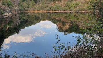 Un lago tranquilo rodeado de colinas boscosas.