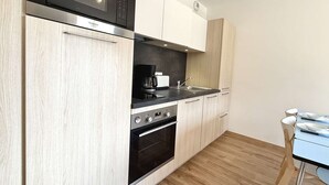 A modern kitchen with a built-in microwave, coffee maker, and oven. - Cozy apartment in Praz-sur-Arly with parking and balcony, near slopes, for 6 people (Praz-sur-Arly)