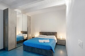 A modern bedroom with a large bed, bedside tables, and a mirror. - Apartment 'Appartamento Vite Vista Piscina' with Sea View, Wi-Fi and Air Conditioning (Montecorice)