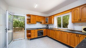 Eine Küche mit Holzausstattung, einem Einbauofen und einem großen Fenster.
