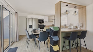 Eine moderne Küche mit Essbereich, inklusive Tisch mit Stühlen, Mikrowelle und Kaffeemaschine.