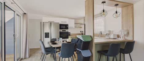A modern kitchen with a dining area, including a table with chairs, a microwave, and a coffee maker.