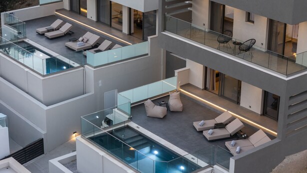 A multi-level modern house with a rooftop pool and outdoor seating areas.