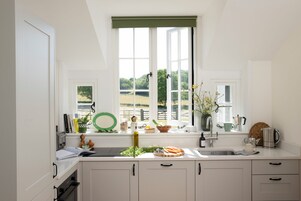 Une cuisine avec une fenêtre, un évier et des placards.