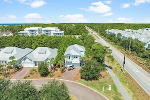 A residential area with multiple houses, a paved road, and a clear sky.