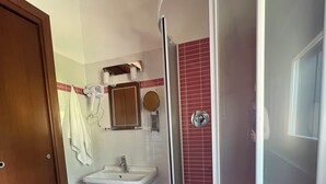 A bathroom with a sink, mirror, and towel rack.