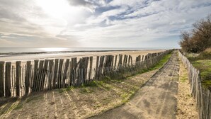 A beach path with wooden posts and a sandy surface leading to the ocean. - Colorful family home with garden for 6 (Longeville-sur-Mer)