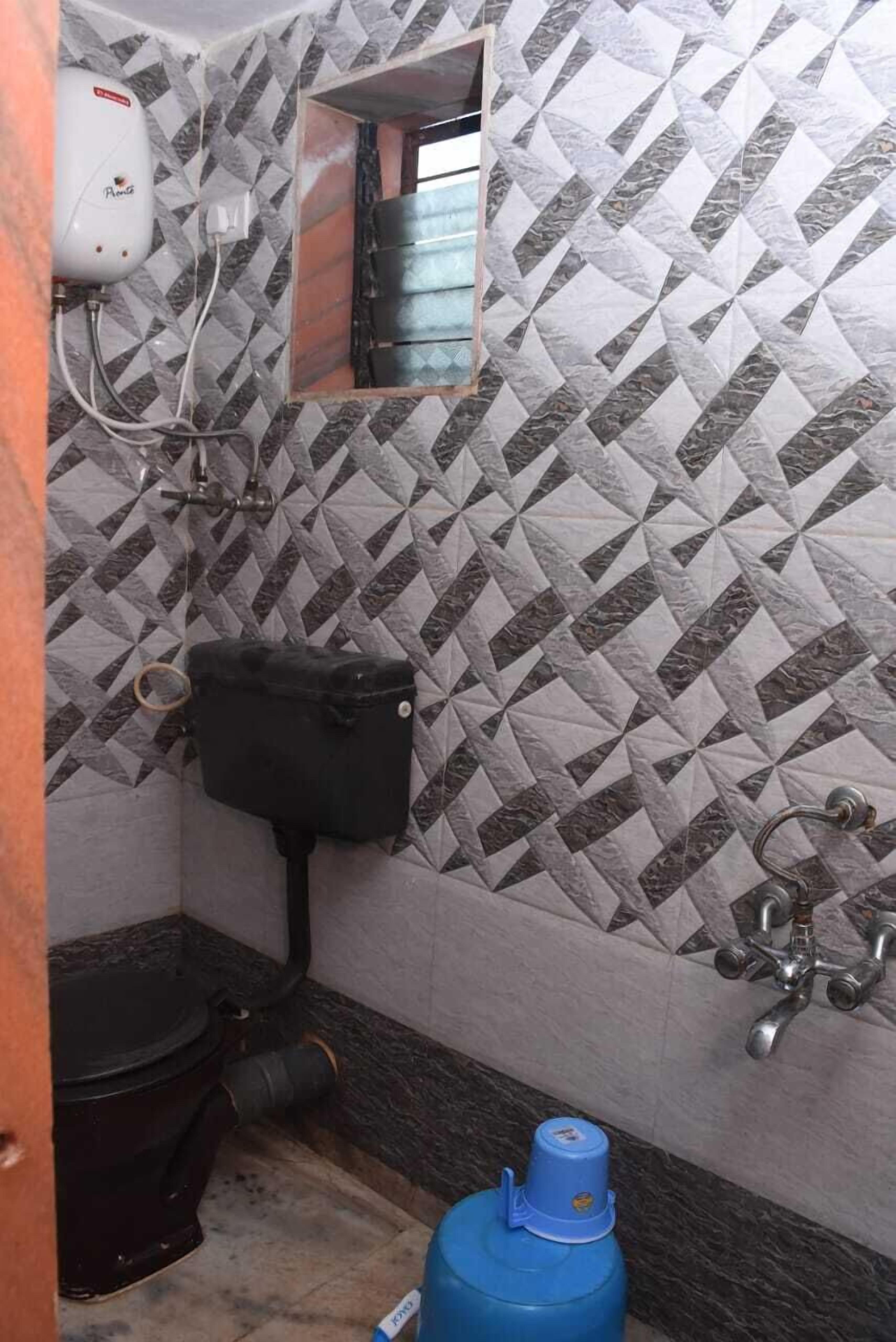 A bathroom with a toilet, a water heater, and a blue gas cylinder.
