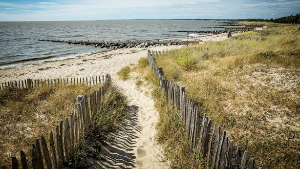 A sandy beach with a wooden fence leading to the water, a rocky breakwater, and a clear sky. - Village house for 4 people, 500m from the sea (La Bernerie-en-Retz)