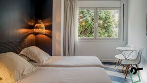 A hotel room with a bed, a desk, and a window with curtains. - Hotiday Barcelona Colom (Barcelona)