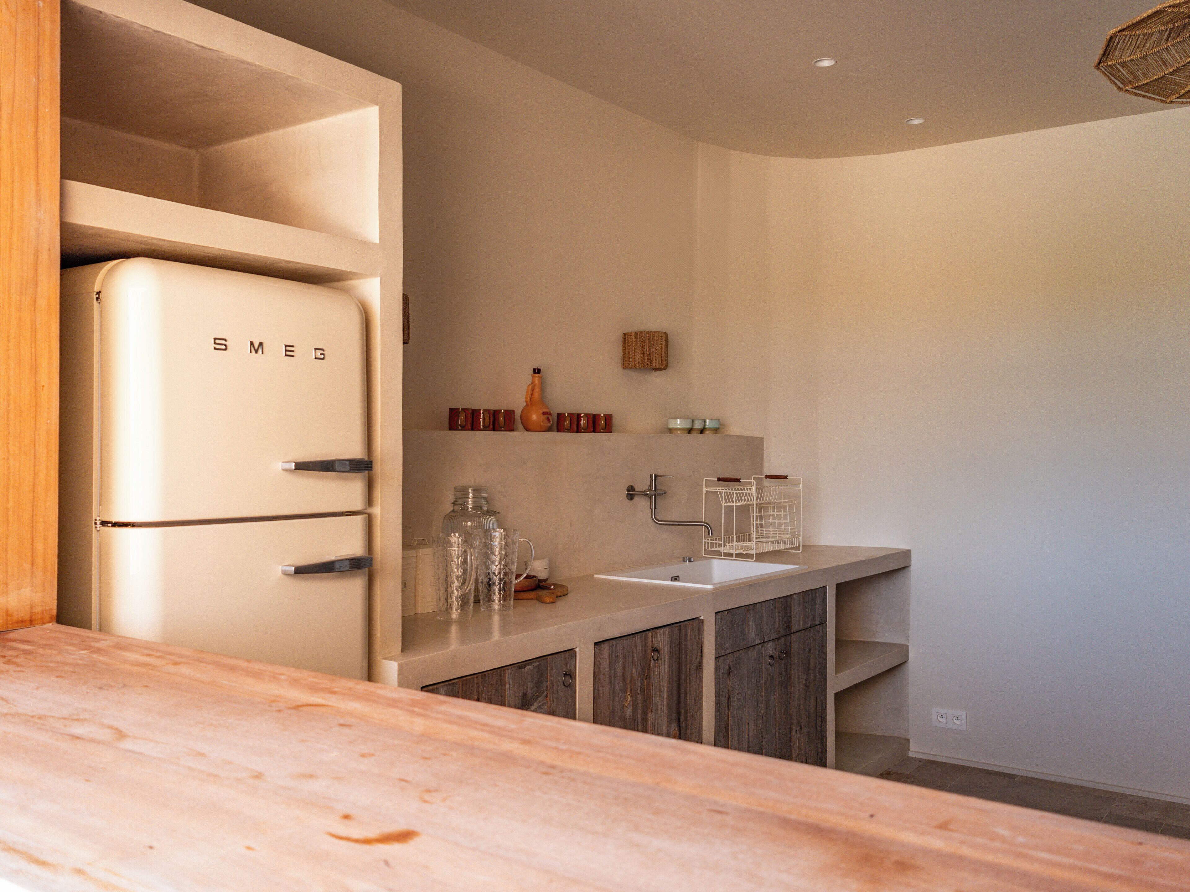 A modern kitchen with a built-in white refrigerator, wooden cabinets, and a countertop.
