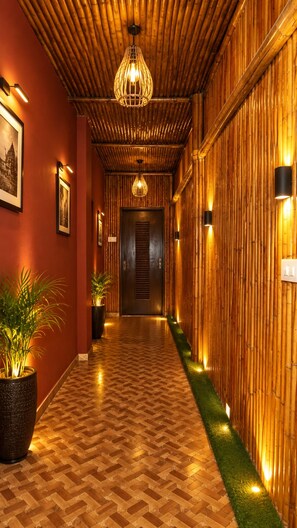 A hallway with a bamboo wall, a patterned floor, and a hanging light fixture. - Venice View Hotel & Restaurant (Udaipur)