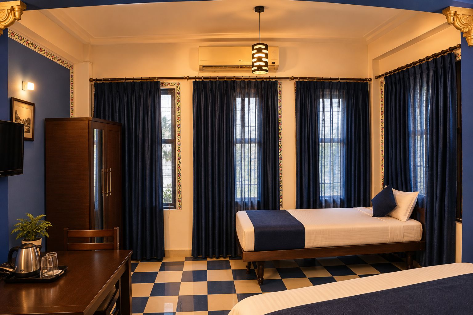 A hotel room with a checkered floor, a bed, a desk with a kettle and glasses, a cabinet, and a large window with curtains.