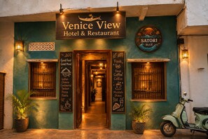 Venice View Hotel & Restaurant with a signboard, a scooter, and a potted plant. - Venice View Hotel & Restaurant (Udaipur)