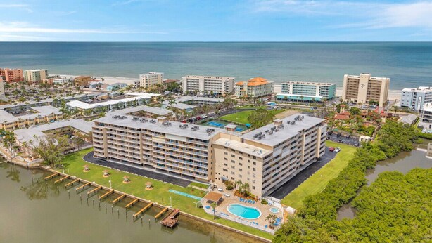 Un hotel costero con varias edificaciones, un puerto deportivo y una zona de piscina.