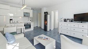 A modern apartment with a kitchen, dining area, living room, and a fireplace.