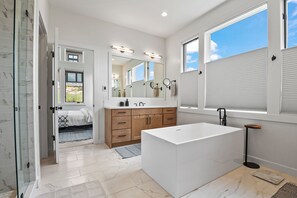 A modern bathroom with a large mirror, a white bathtub, and a walk-in shower. - Red Ledges vista, hottub, golf, min 90 day stay (Heber City)