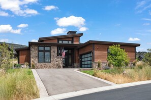 A modern two-story house with a stone facade, large windows, and a garage. - Red Ledges vista, hottub, golf, min 90 day stay (Heber City)