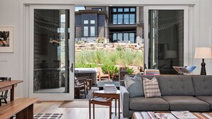 A modern living room with a grey sofa, wooden coffee table, and a dining area with a wooden table and chairs. - Red Ledges vista, hottub, golf, min 90 day stay (Heber City)